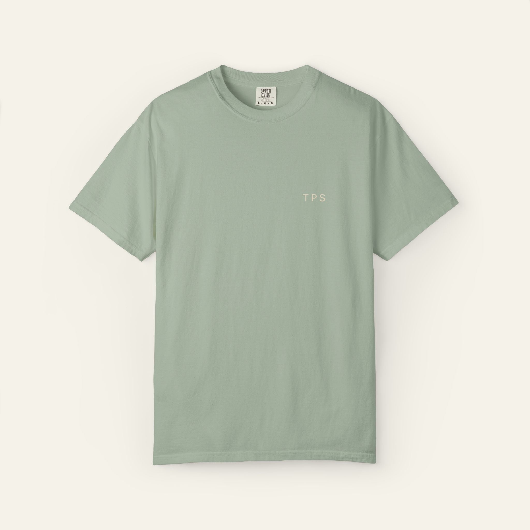 Sage green t-shirt with 'TPS' text on a neutral background